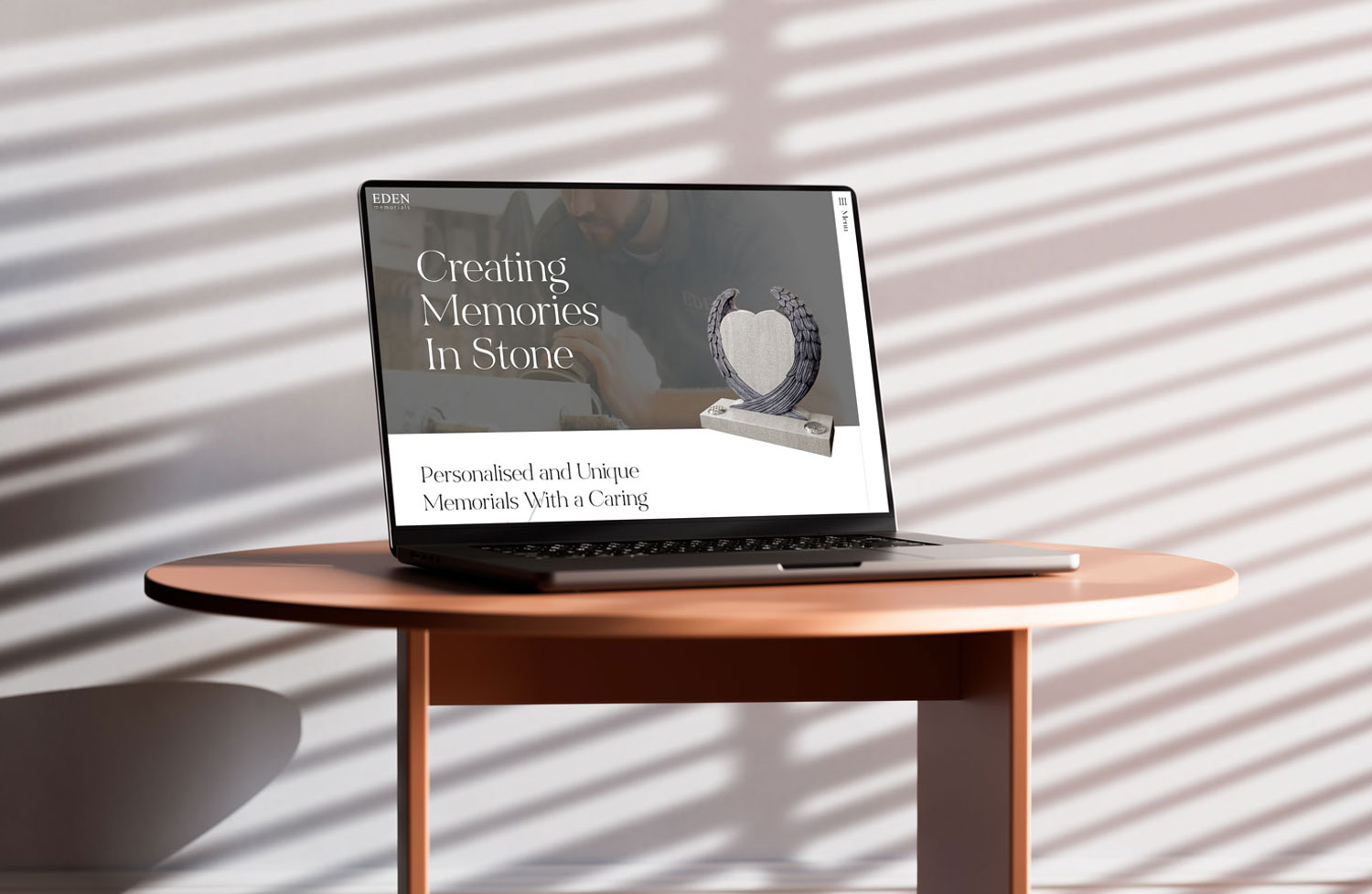 A laptop on a desk with the Eden Memorials website.