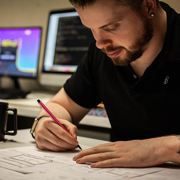 An image of BurstingBox sketching initial logo ideas.