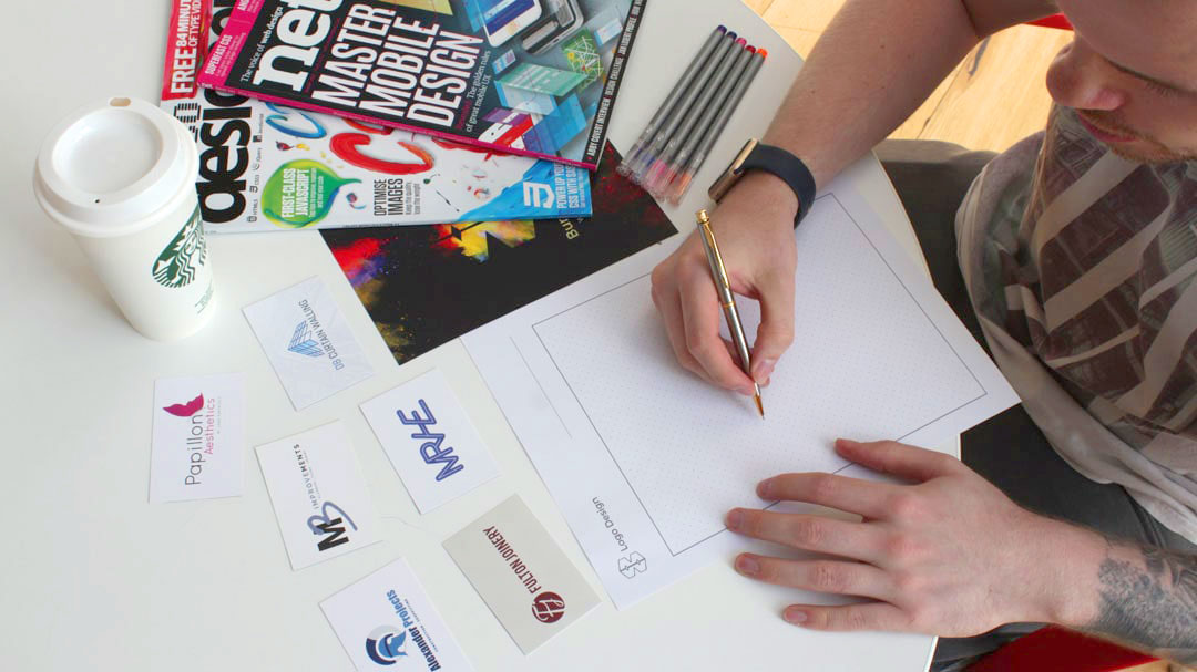 An image of Gav drawing a logo with a pencil and paper.